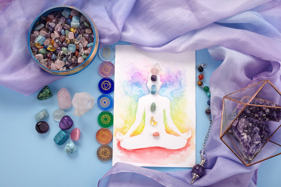 Natural crystals and pendulum on pastel silk background. Reiki background with card.